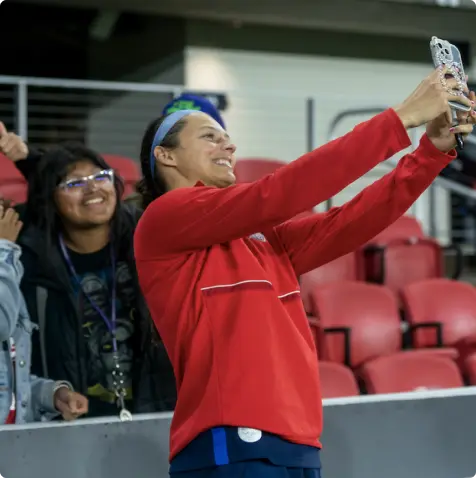 Soccer player taking a selfie with fans