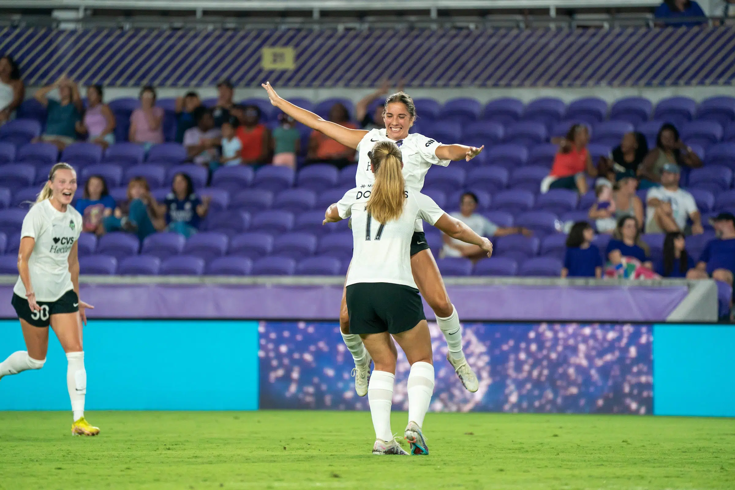 Two soccer players jump up to embrace.