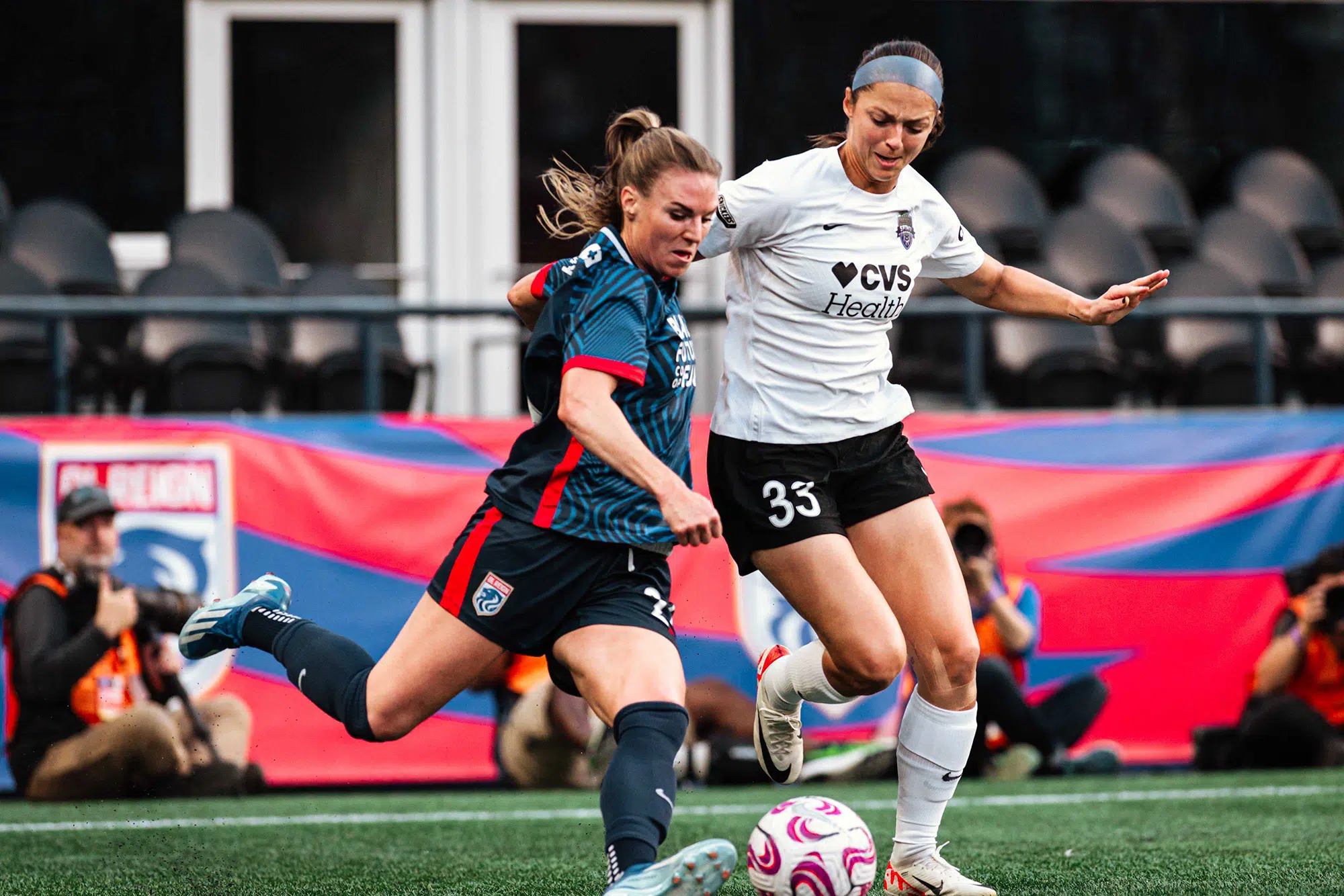 Ashley Hatch battles for possession of the soccer ball against an OL Reign player.