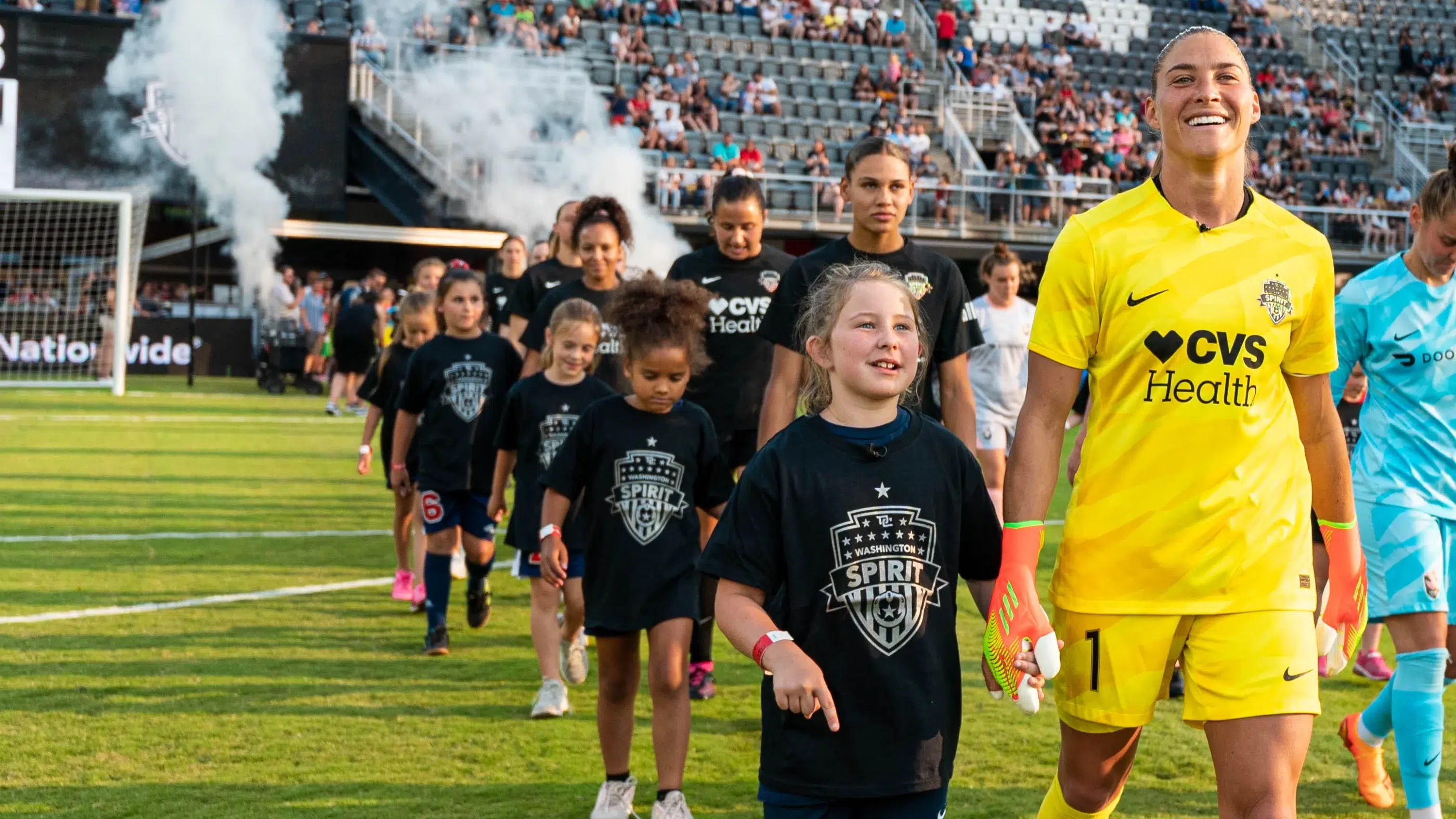 Aubrey Kingsbury and youth soccer player Avery walk onto Audi Field before the Washington Spirit match against Angel City FC.