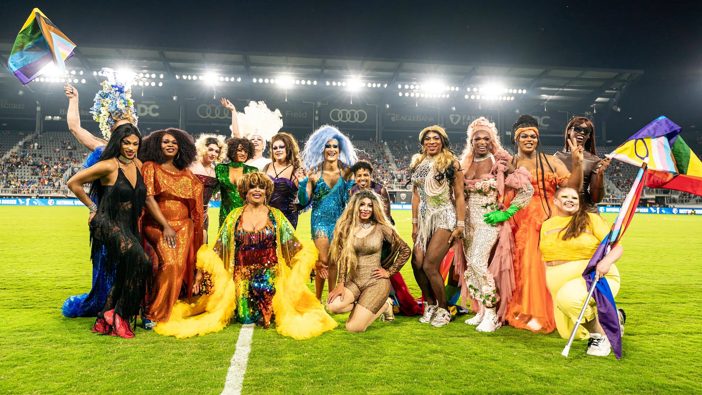 More than a dozen drag queens and kings pose for a photo on Audi Field after performing at halftime of the Spirt vs. Racing Louisville soccer game.