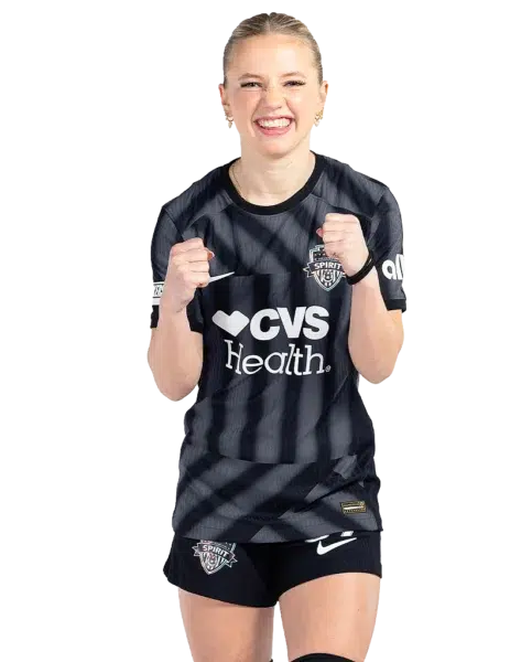 Chloe Ricketts clenches her fist in excitement while wearing a black and gray striped Spirit kit.