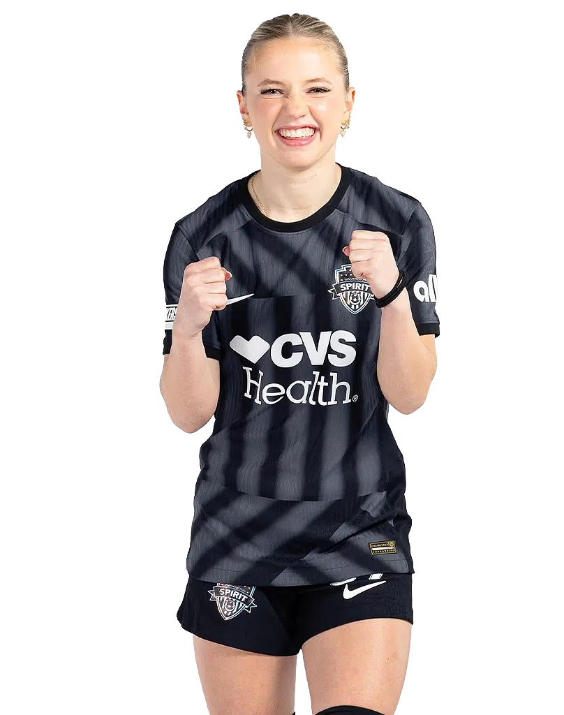 Chloe Ricketts clenches her fist in excitement while wearing a black and gray striped Spirit kit.