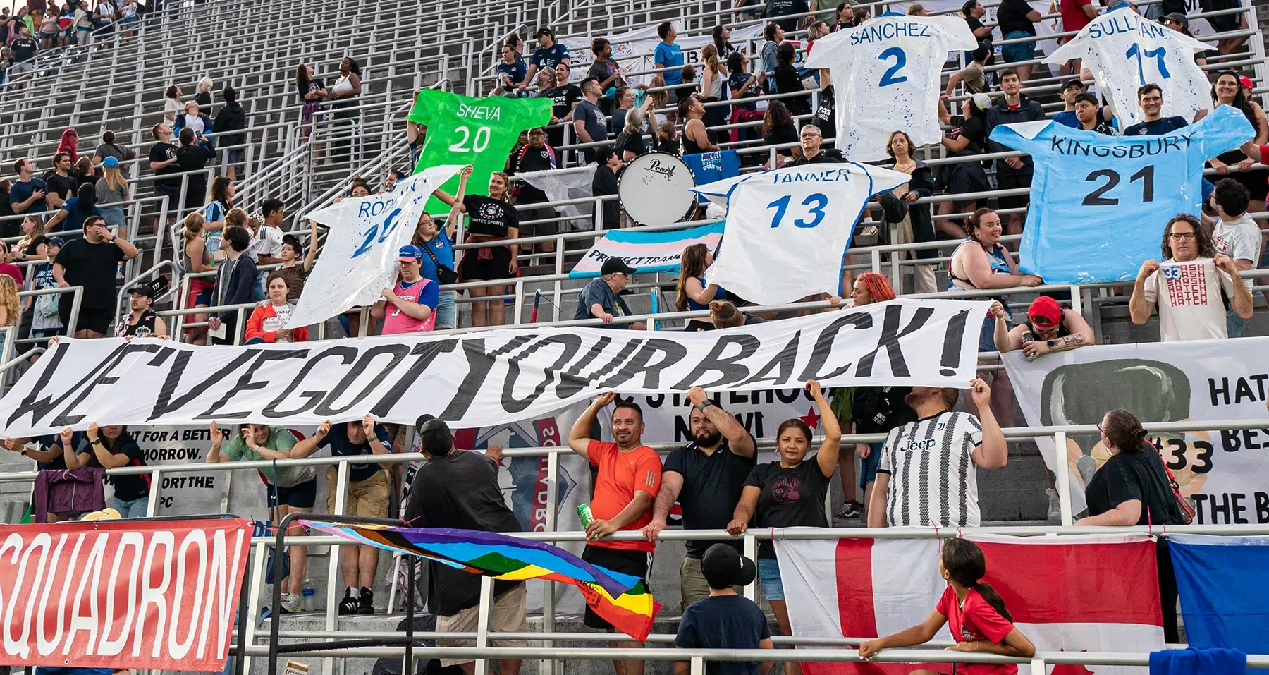 Members of the Spirit Squadron fold up a tifo that reads "We've got your back!" and individual tifos cut into the shape of soccer jerseys with the names and numbers of the six Spirit players going to the FIFA Women's World Cup.