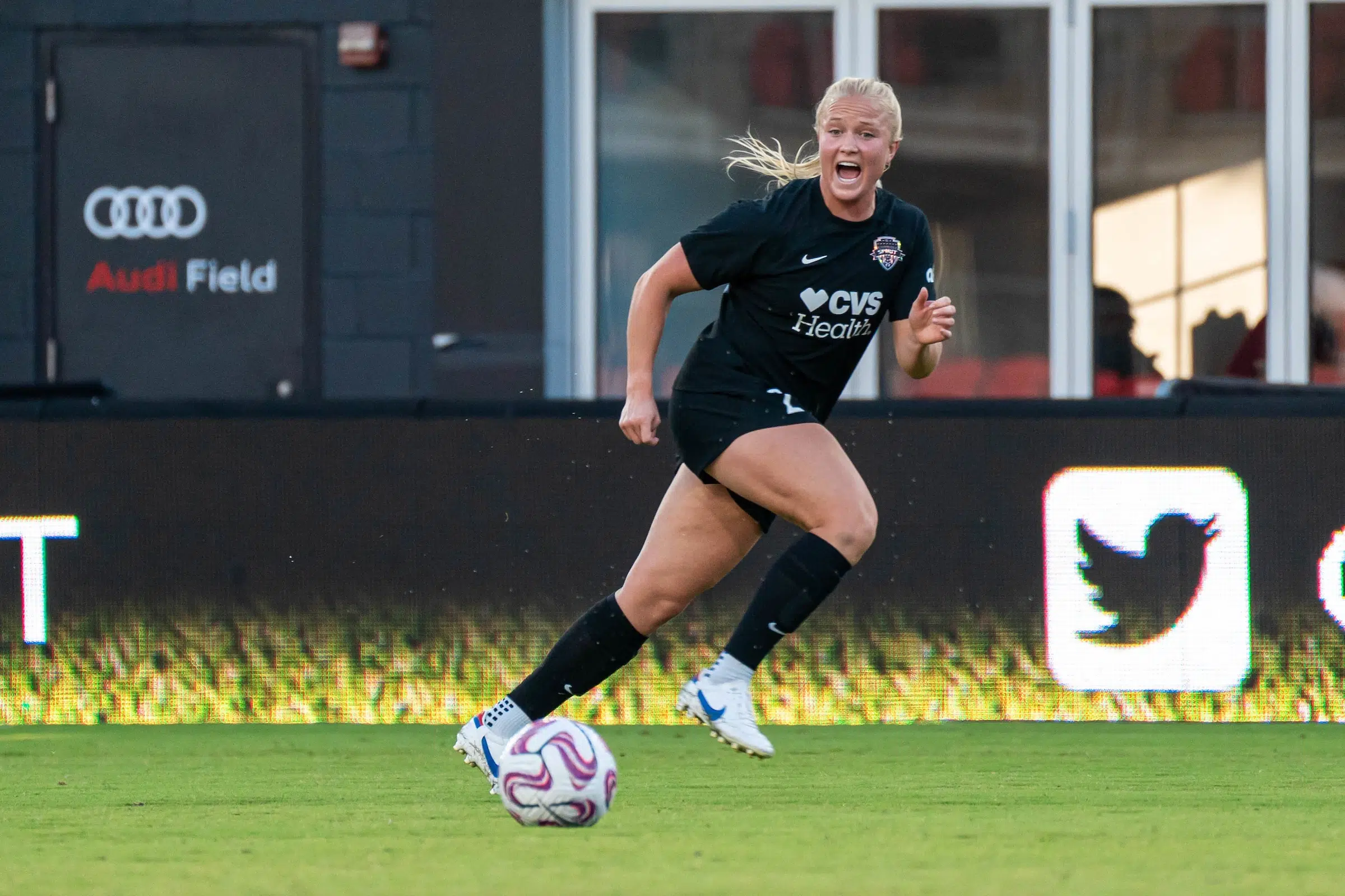 Civana Kuhlmann in a black uniform runs down the field and calls for the ball.
