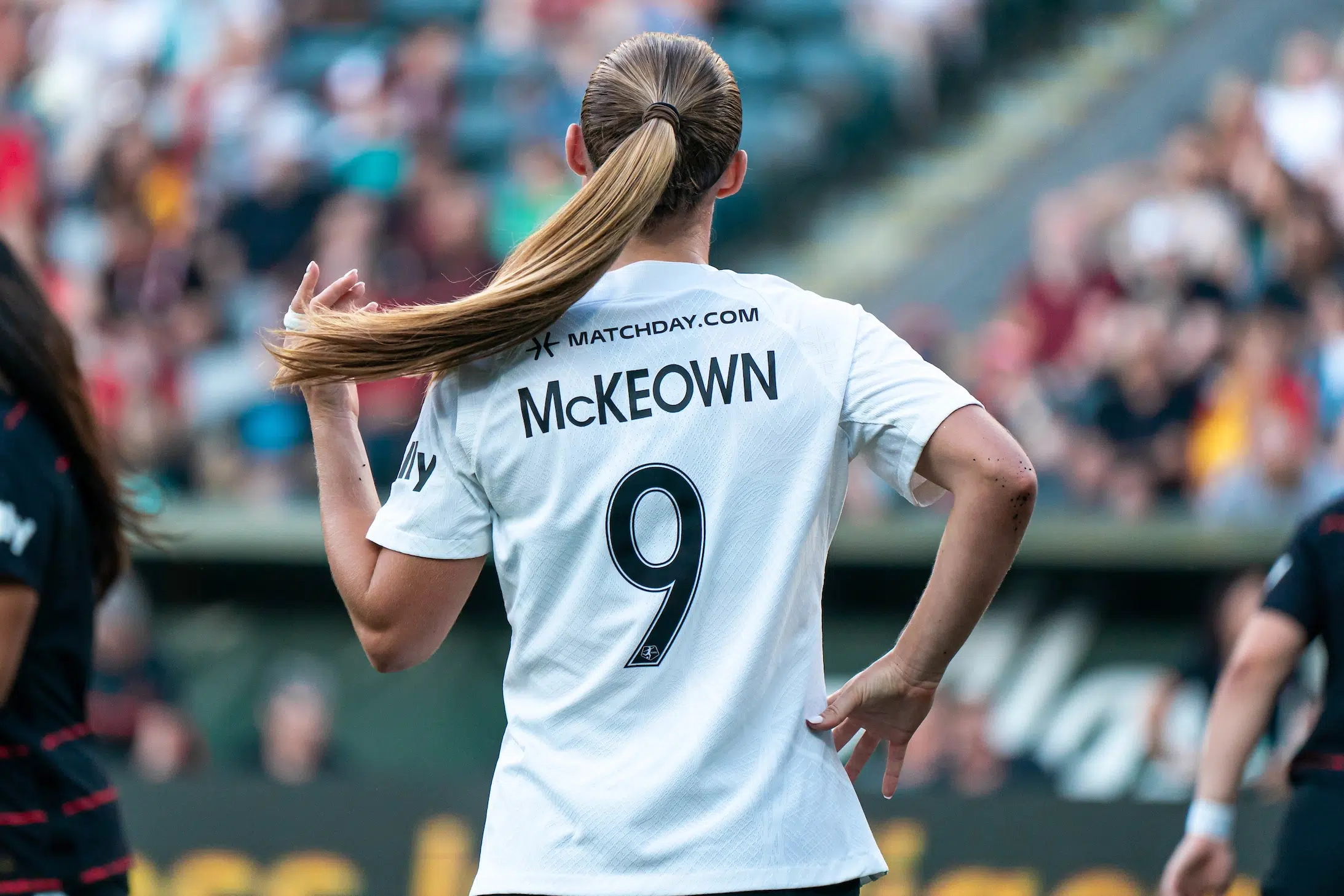 Tara McKeown fixes her ponytail, revealing her last name and number 9 on the back of her jersey.