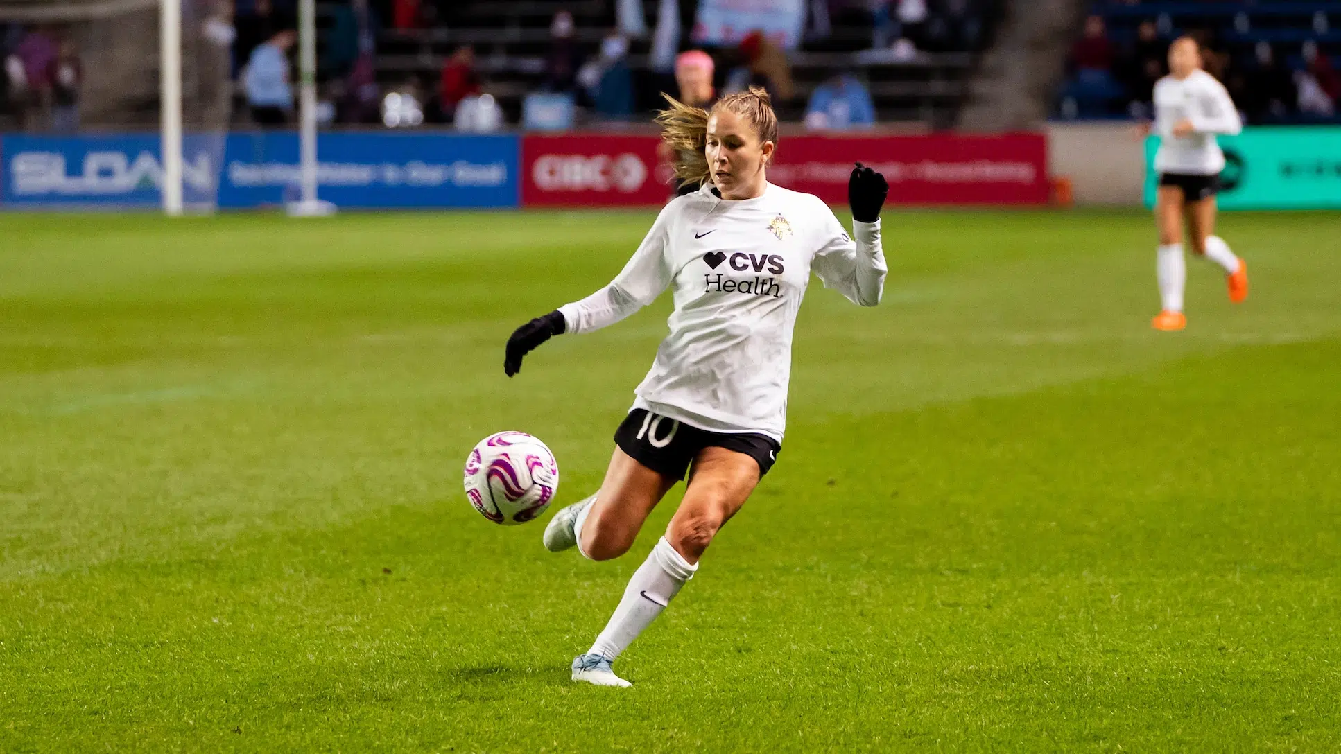 Kitted in a white Spirit jersey, black shorts, white socks and black gloves, Ashley Sanchez prepares to trap a soccer ball.