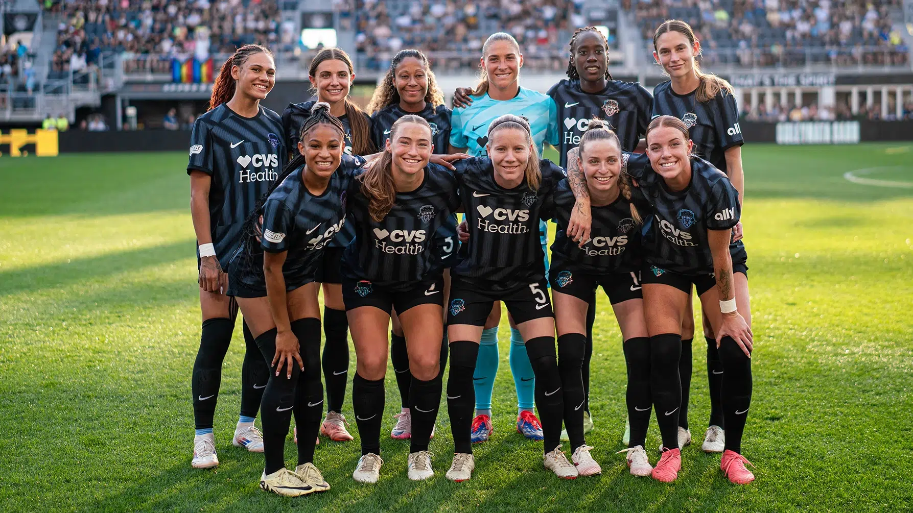 The starting eleven for the Spirit in two rows wearing black jerseys.