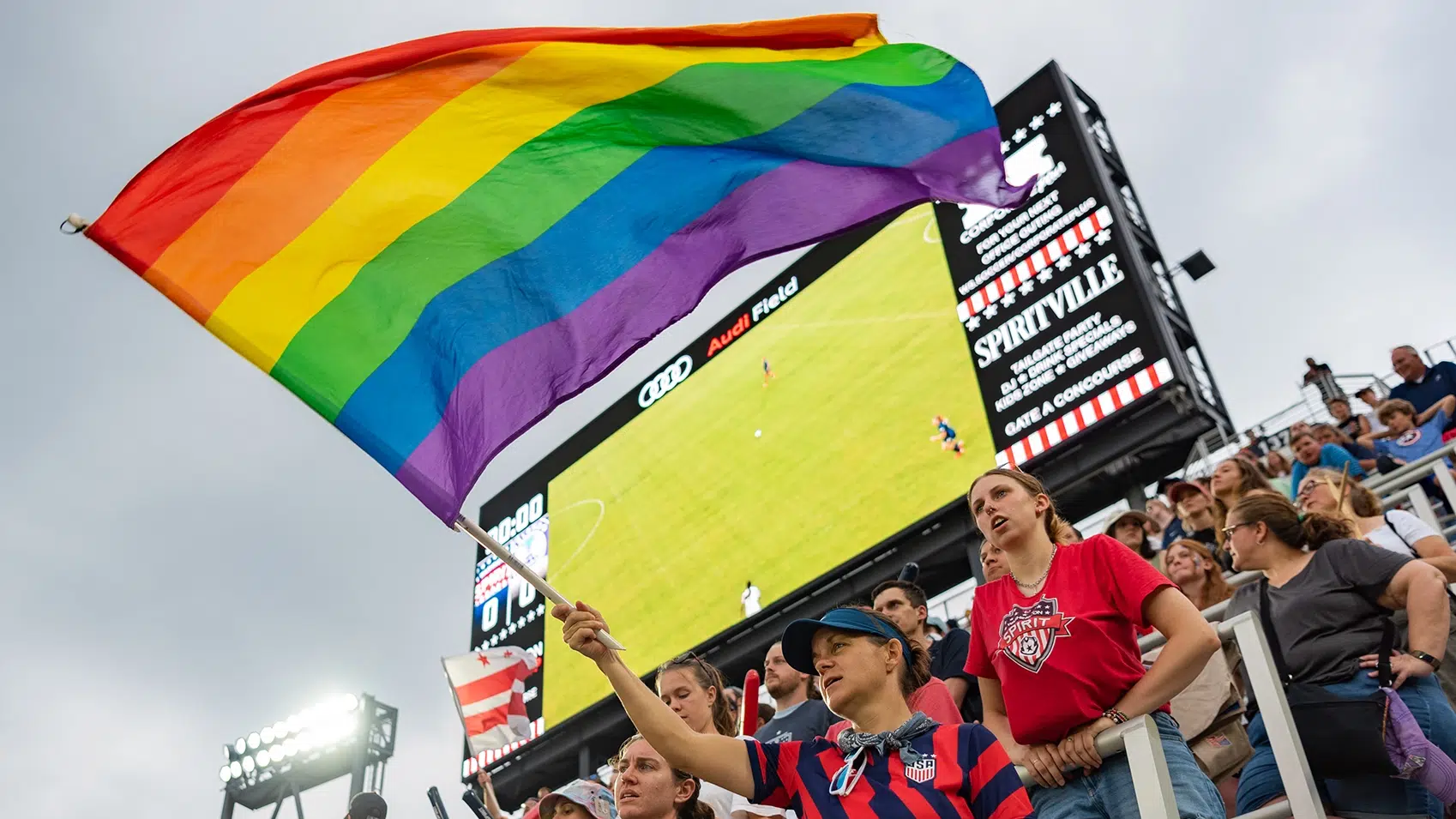 Fans waving a gay pride flag.
