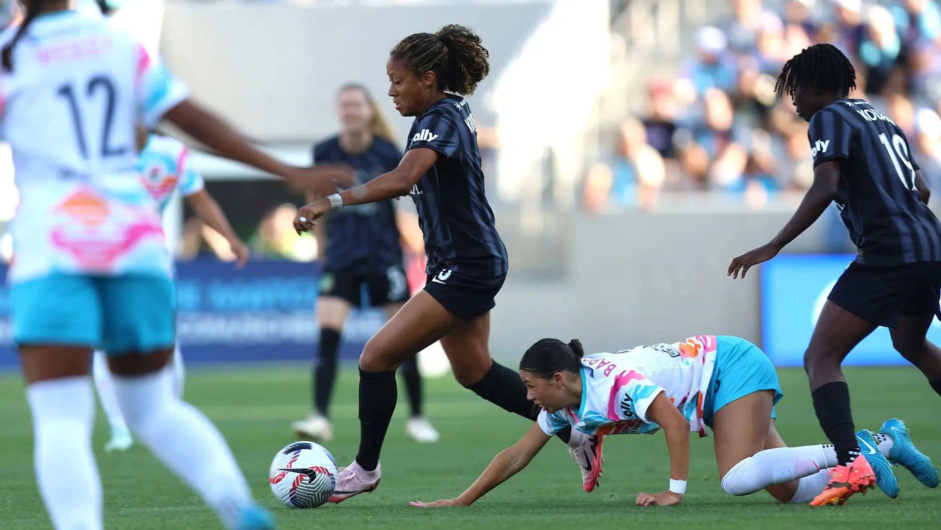 Casey Krueger dribbles the ball away from a San Diego Wave defender.