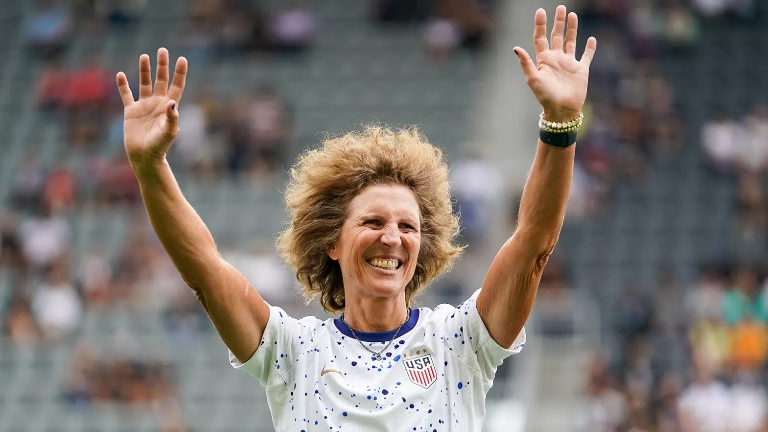 Honorary captain Michelle Akers waves to the crowd.