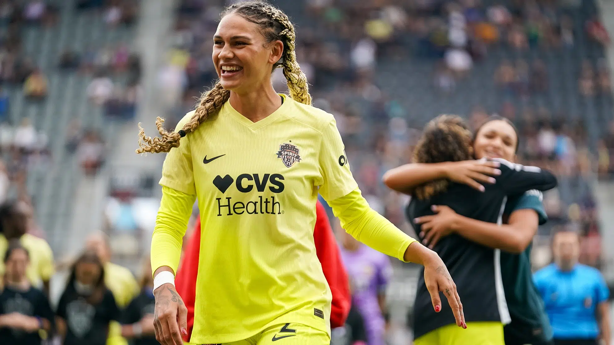 Trinity Rodman smiles in a yellow kit.