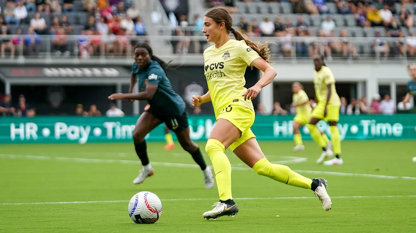 Courtney Brown dribbles the ball in a yellow kit.