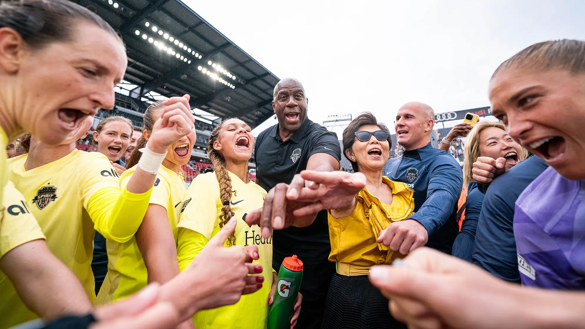 Magic Johnson, Michele Kang, and the Spirit huddle up.