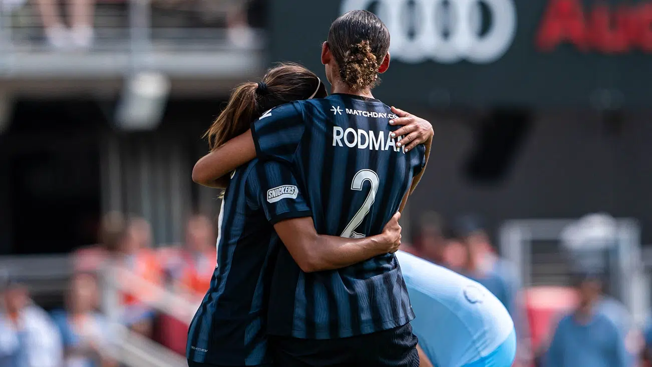 Leicy Santos hugs Trinity Rodman.