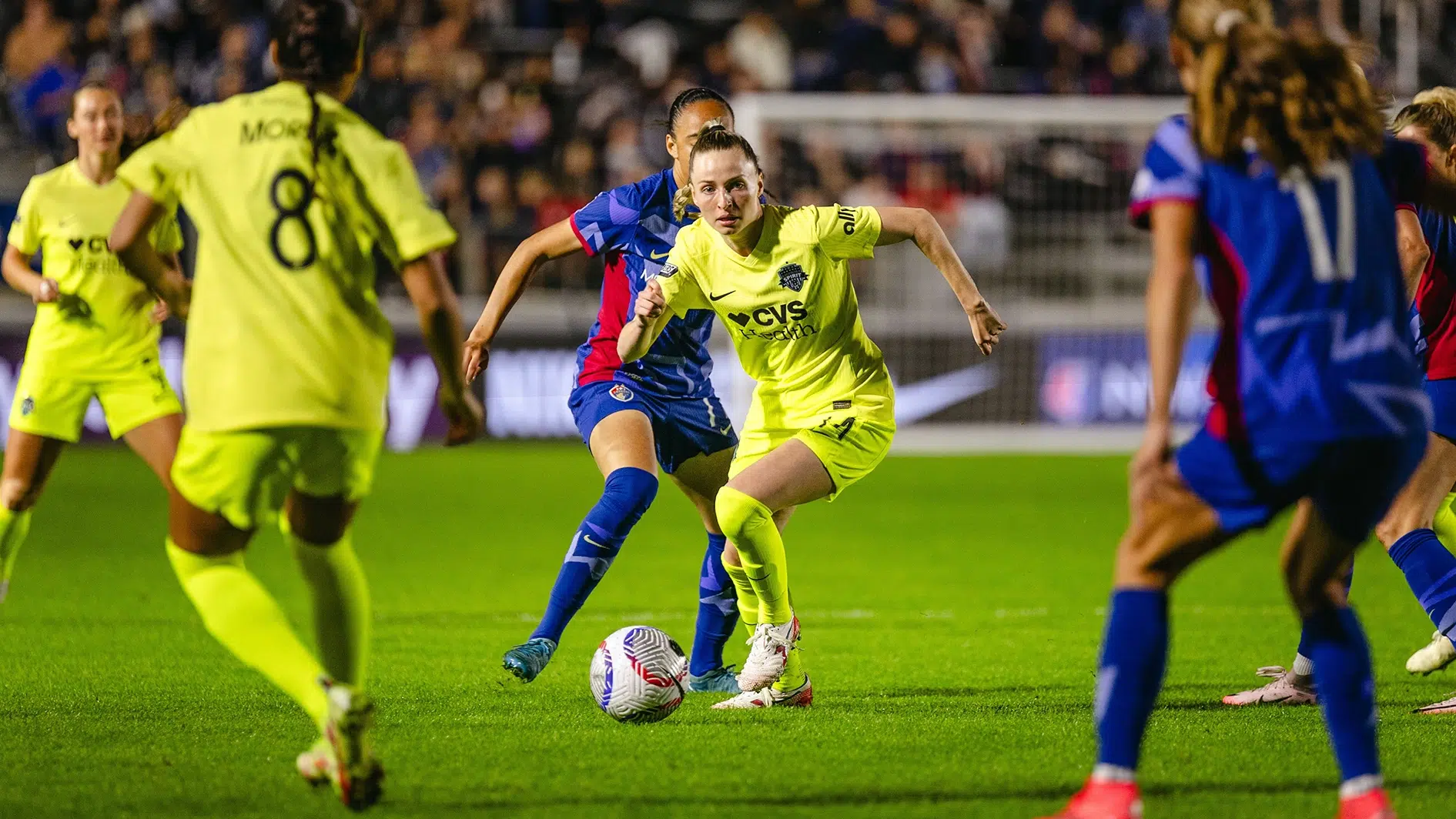 Gabby Carle dribbles the ball through multiple defenders.