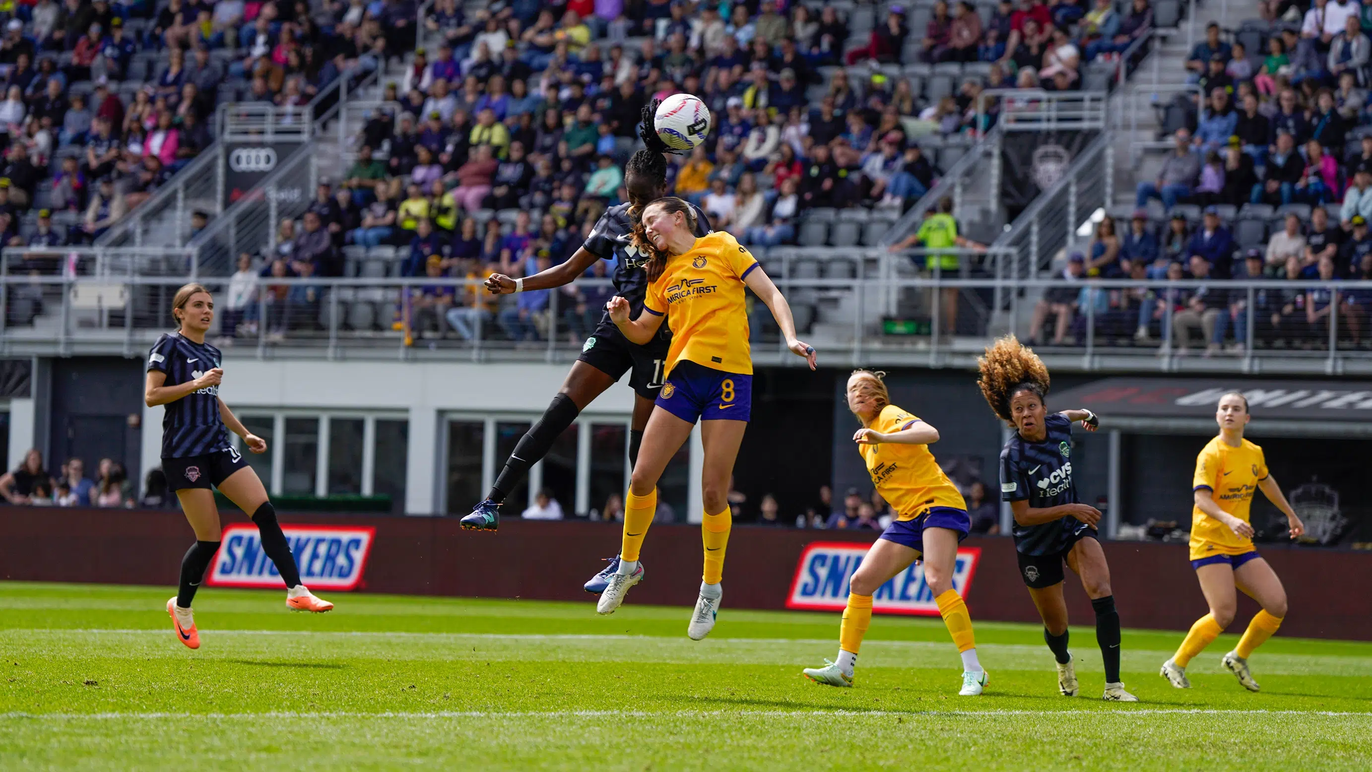 Ouleye Sarr and a Utah Royals player jump up to head a soccer ball.
