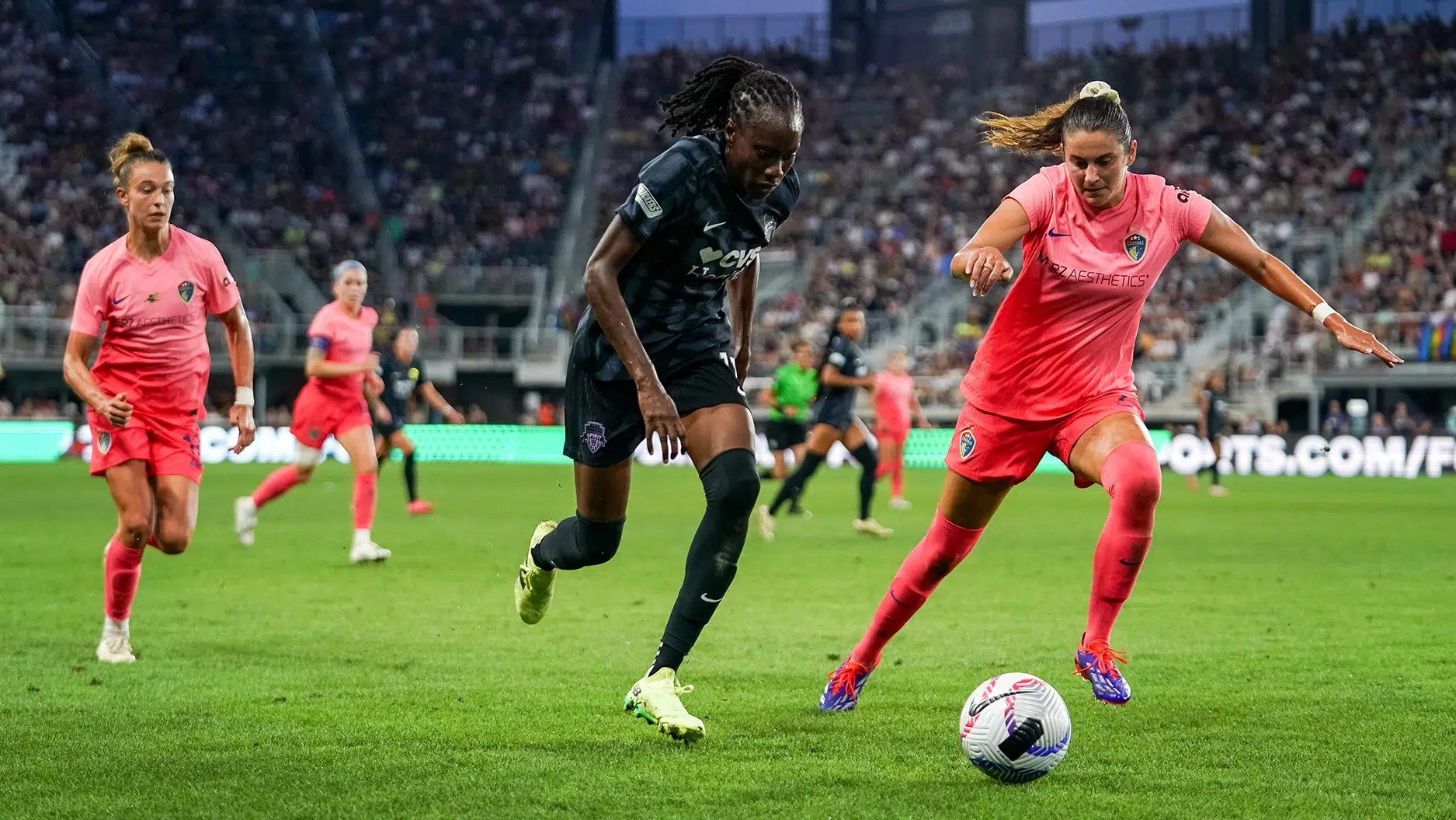 Ouleye Sarr dribbles the ball passed a NC Courage defender in pink.