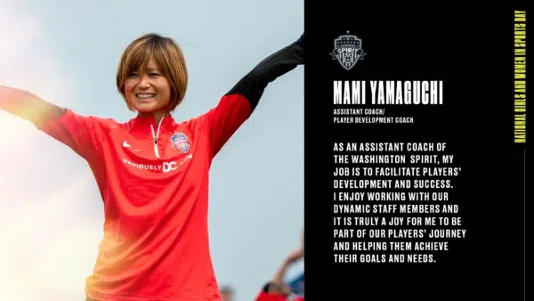 Mami Yamaguchi lifts her arms and smiles while wearing a red Nike quarterzip top.