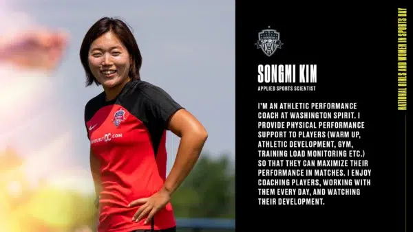 Songmi Kim puts her hands on her hips while wearing a red Spirit training t-shirt. 