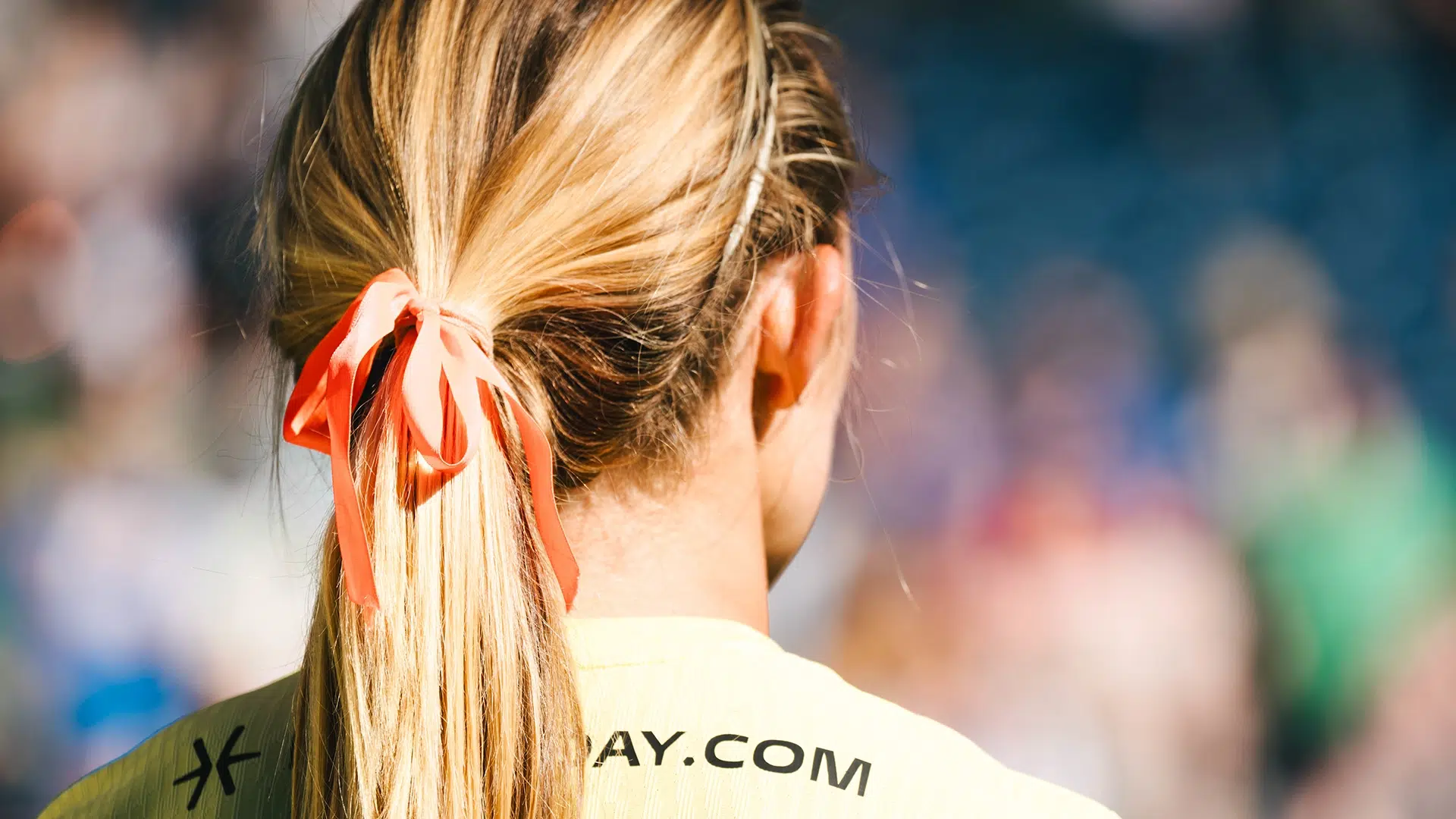 A view of Brittany Ratcliffe's blonde hair in a ponytail tied with an orange ribbon.