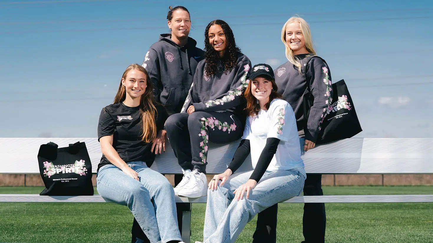 Spirit players wearing various pieces from the Cherry Blossom capsule including sweatpants, sweatshirts, short sleeve t-shirts, and tote bags.