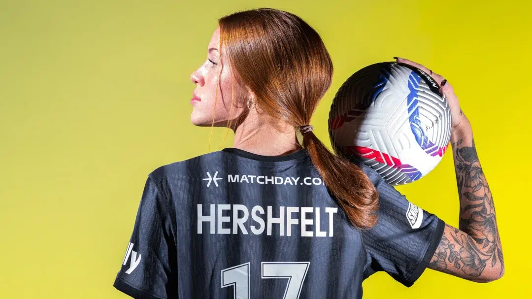 Hal Hershfelt turns her head to the left while holding a ball in her right hand. Her back is to the camera and you see her last name and number 17.