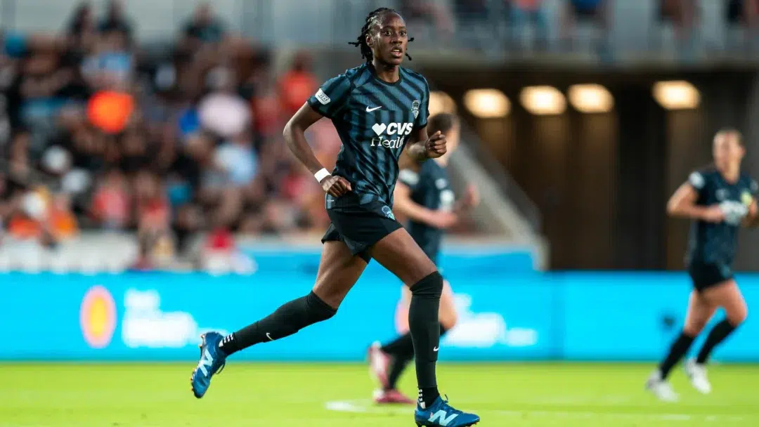 Ouleye Sarr in a black Spirit kit runs on a soccer field.