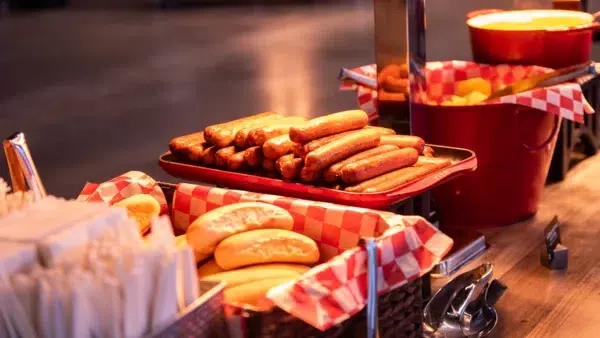 Hot dogs, buns, and chips on a buffet table.