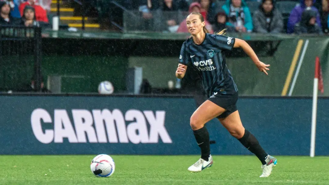 Tara McKeown dribbles the soccer ball while wearing a black Spirit kit.