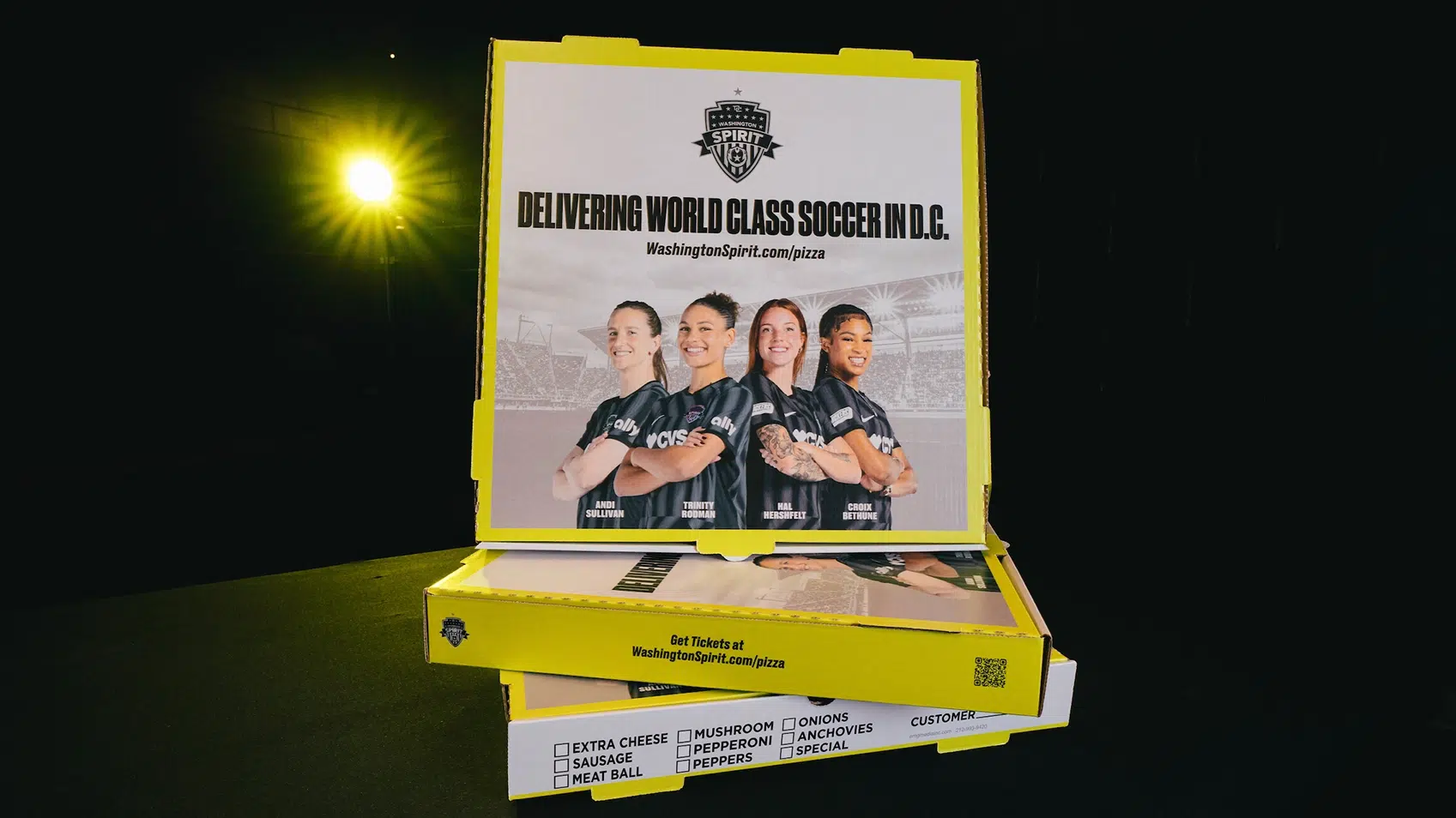A stack of Spirit-branded pizza boxes.