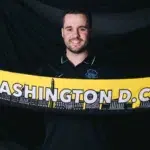 Jonatan Giráldez holds up a yellow Spirit scarf.