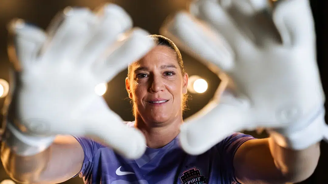 Nicole Barnhart holds up her hands wearing goalie gloves.