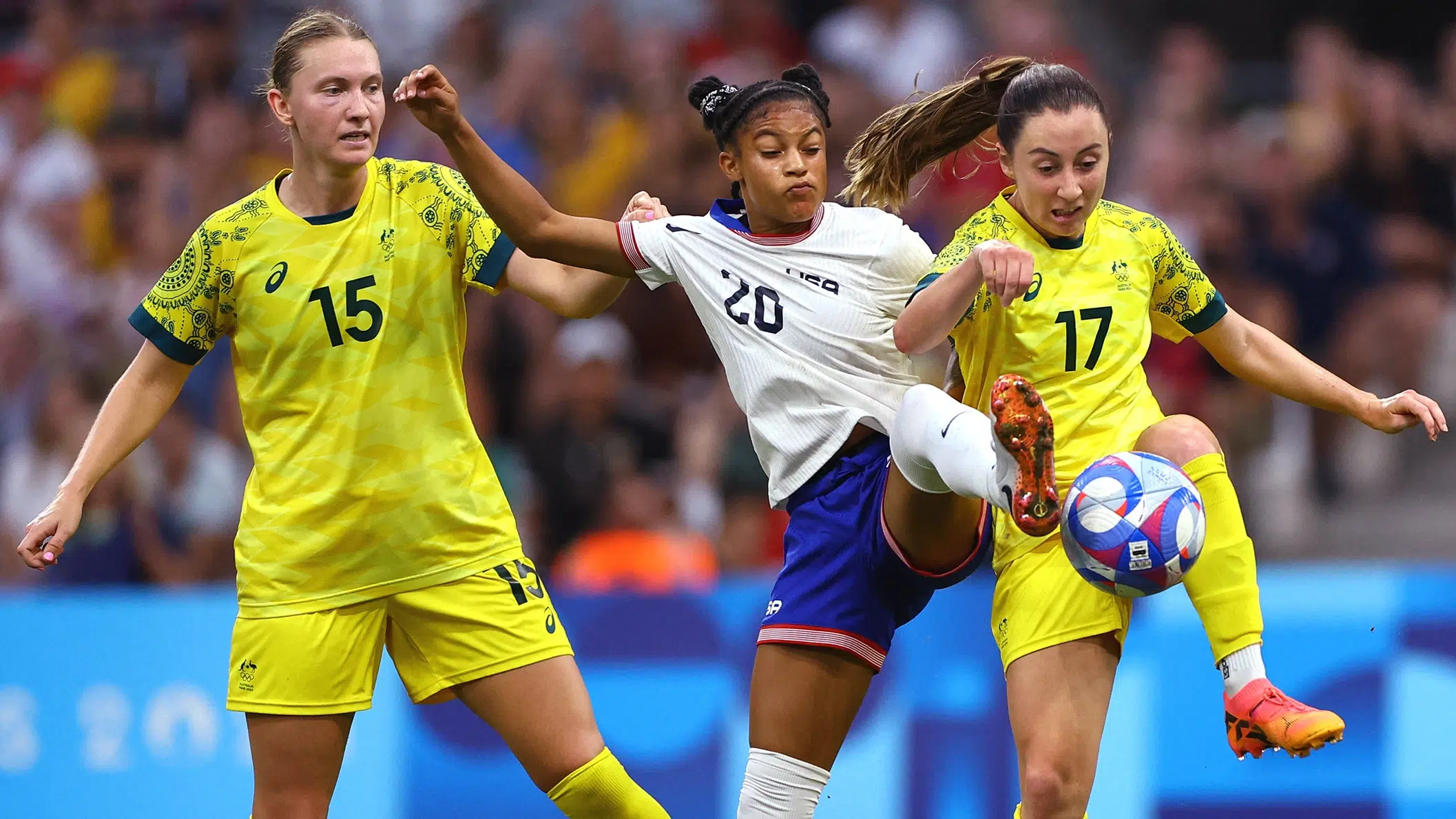 Croix Bethune battles for the ball against two Australian players.