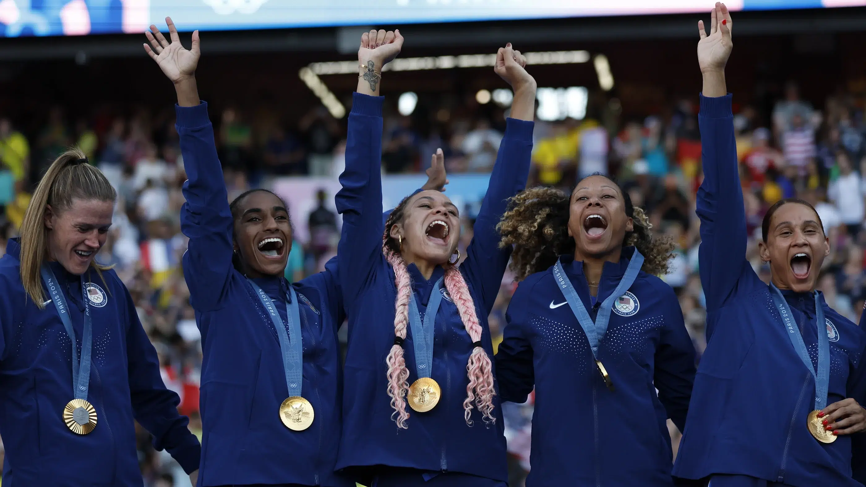 Alyssa Naeher, Naomi Girma, Trinity Rodman, Casey Krueger, and Lynn Williams celebrate gold.