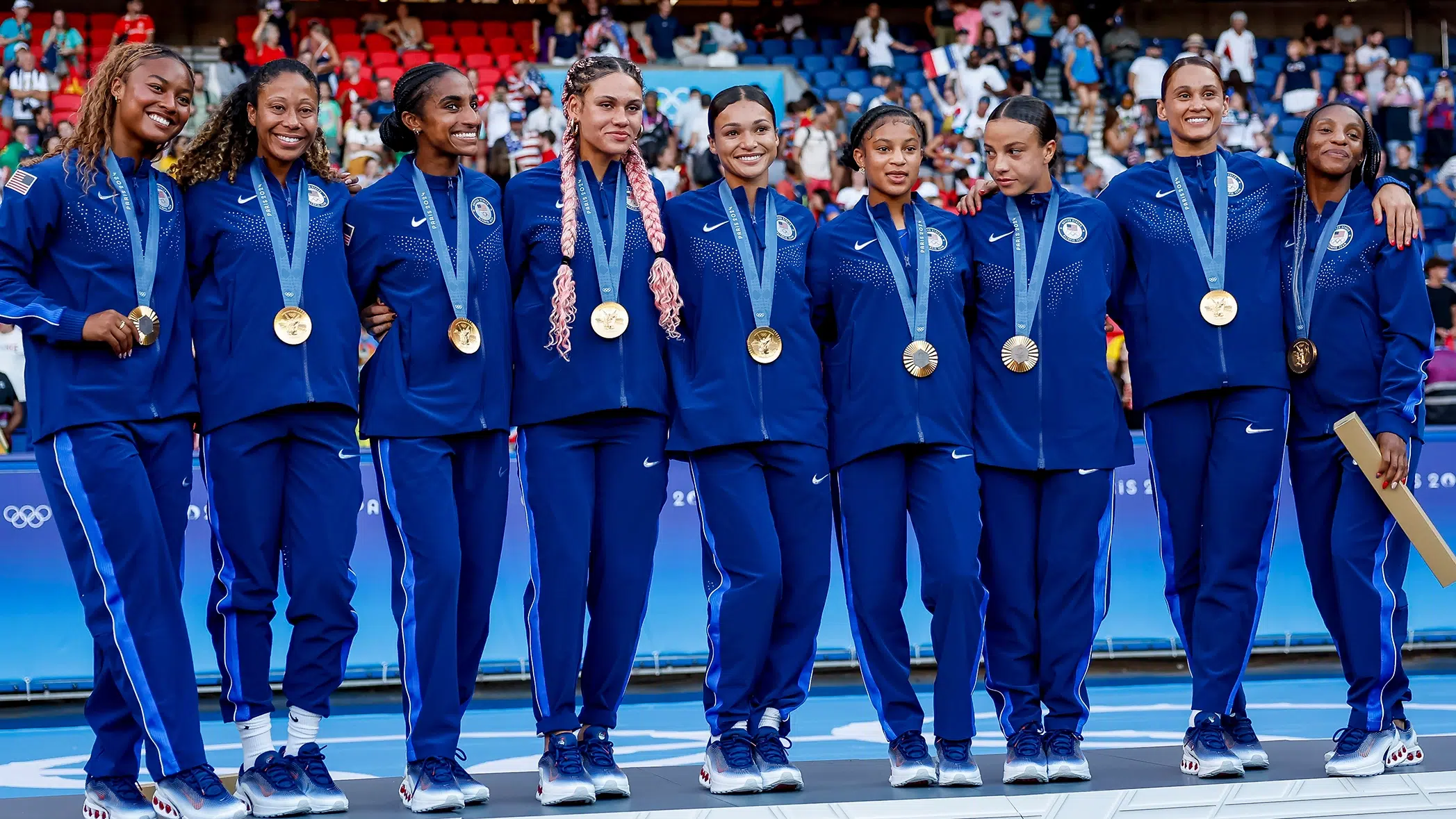 Members of the USWNT smile with their gold medals.