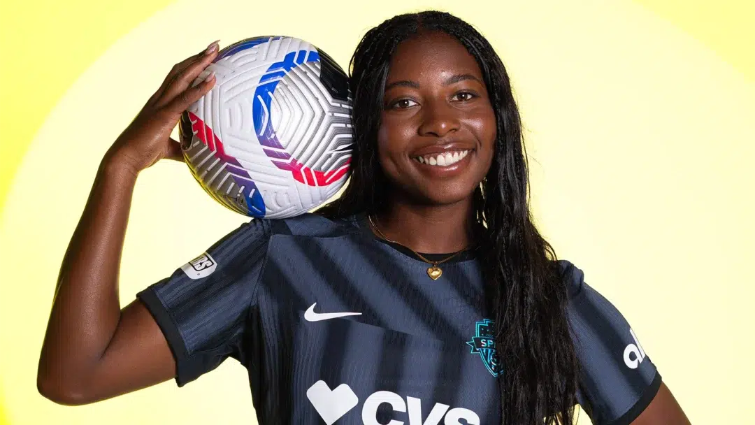 Waniya Hudson in a black Spirit jersey in front of a yellow background.