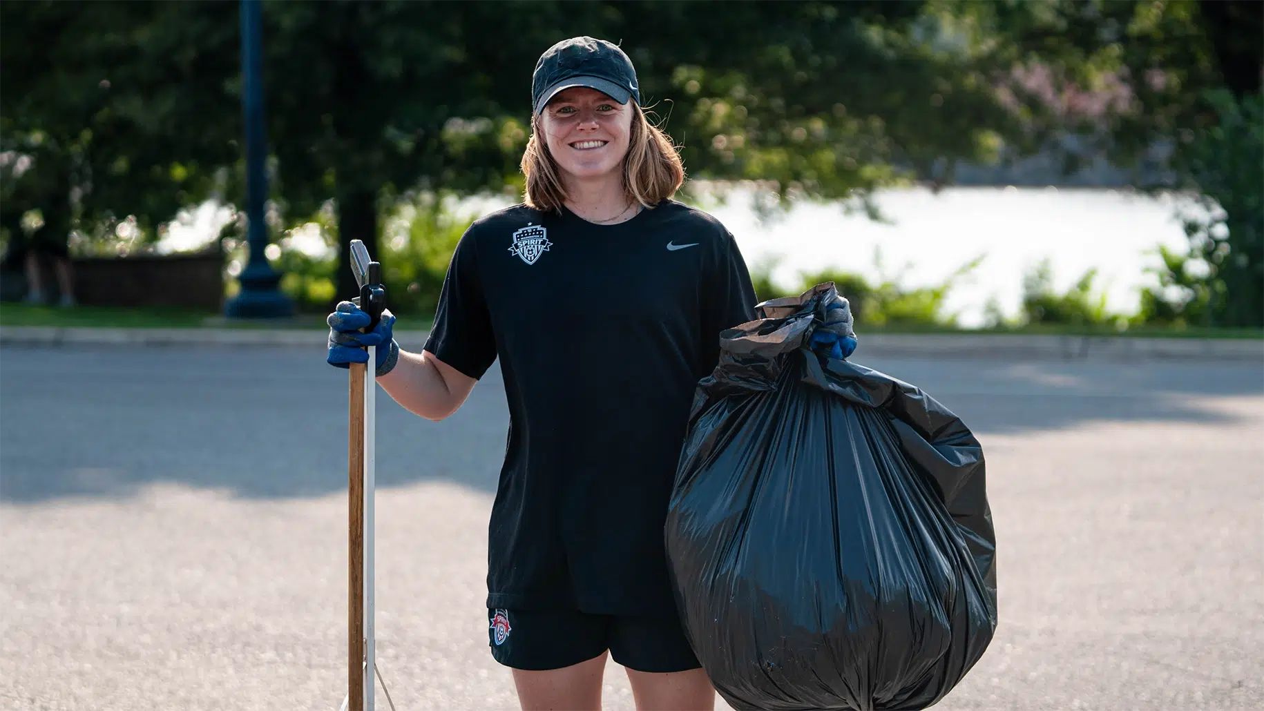 Anna Heilferty holding up a bag of trash she has collected.