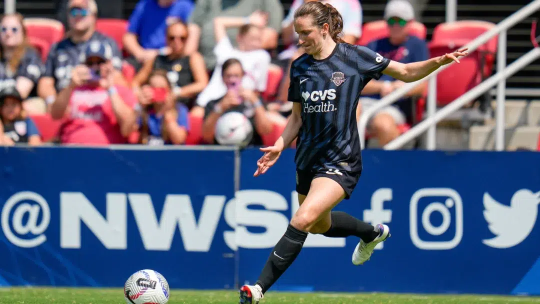 Andi Sullivan kicks a soccer ball.