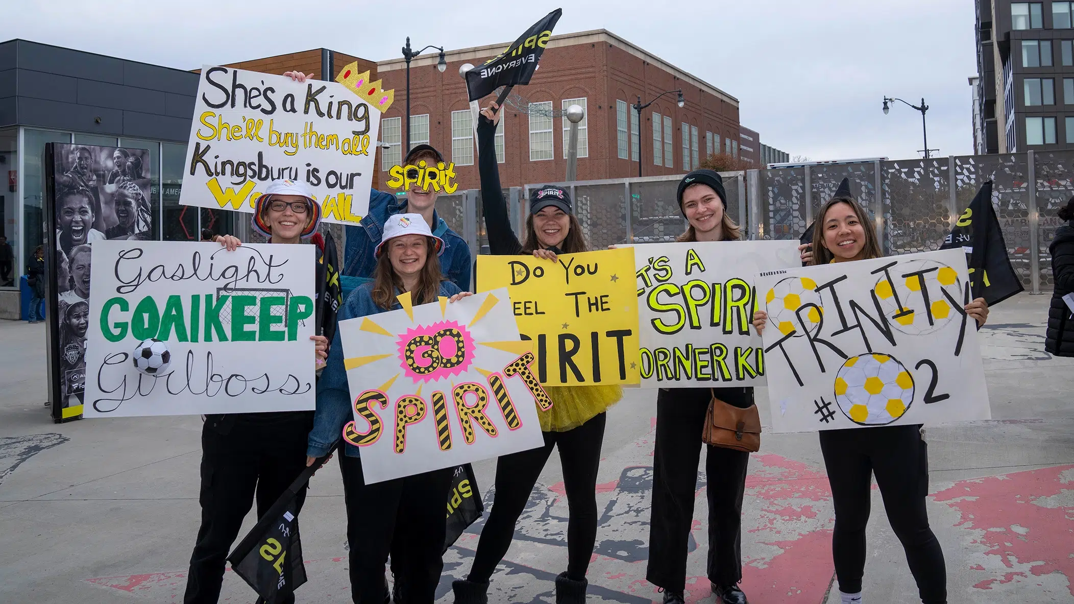 A group of fans holding handmade posters supporting the Spirit.