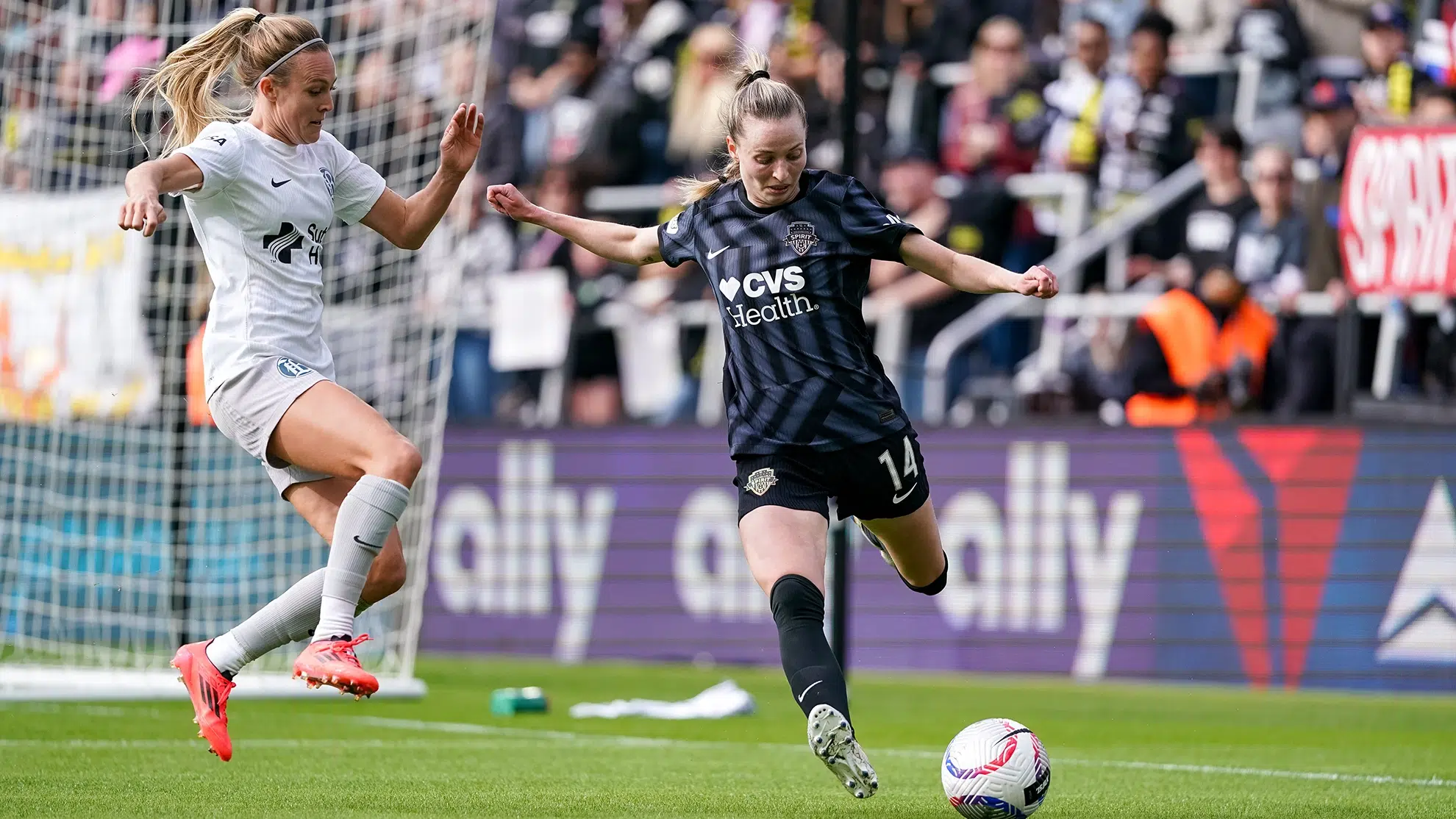 Gabby Carle kicks the ball away from a defender.