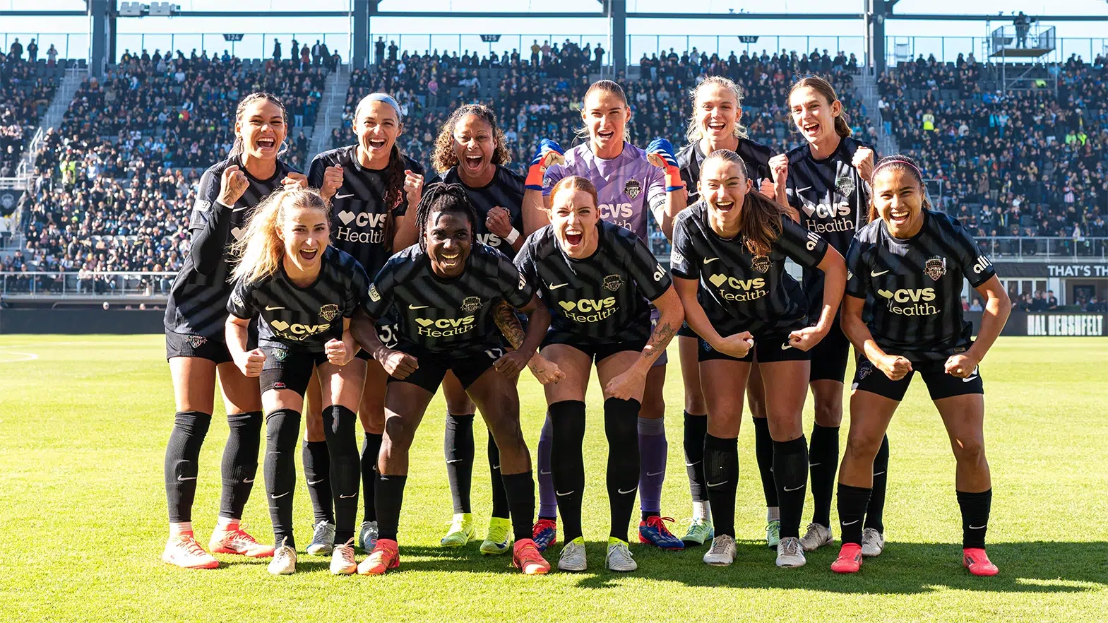 The Starting XI for the Washington Spirit in black uniforms make growling faces.