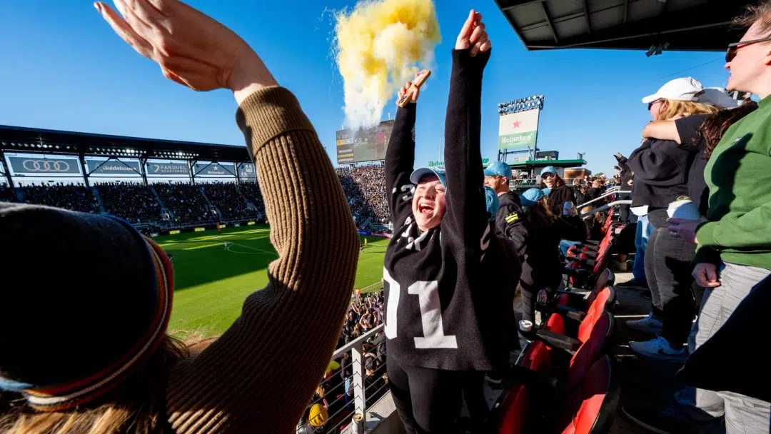 Spirit fans throw their hands in the air in celebration.