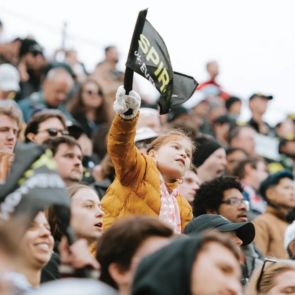 A young fan waves a spirit flag