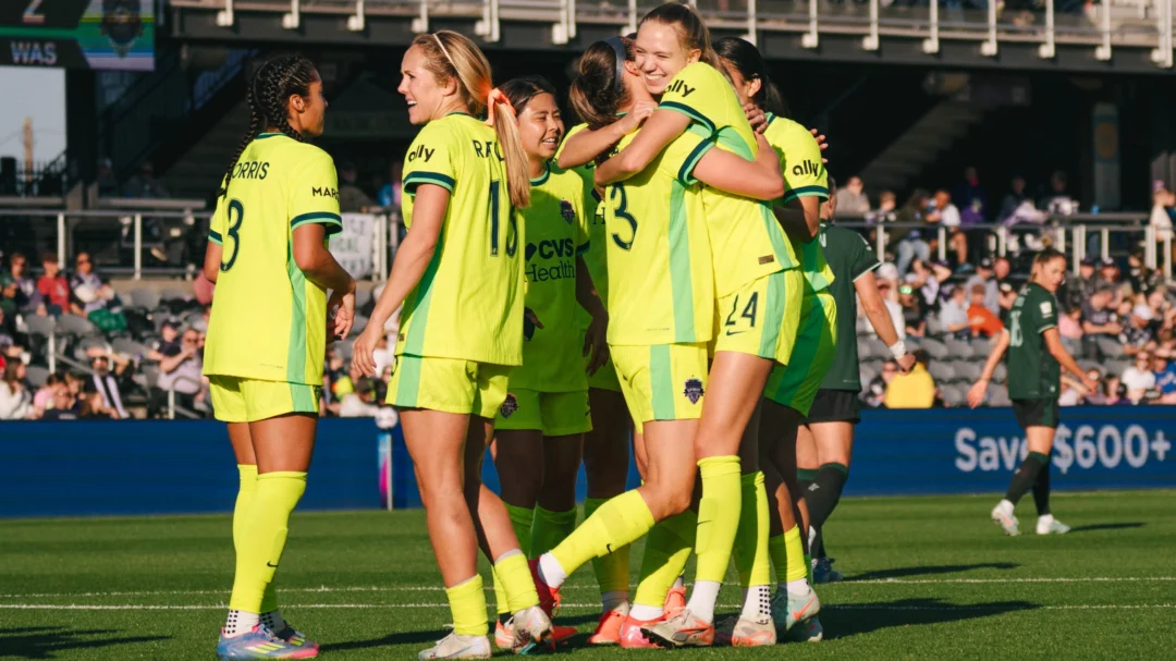 Spirit players hug while wearing Shockwave yellow kits.