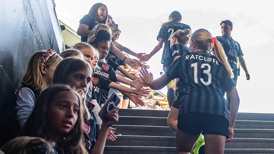 Young fans high five Spirit players.