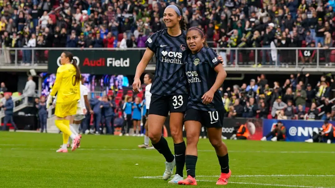 Ashley Hatch and Leicy Santos on the field in black Spirit kits.