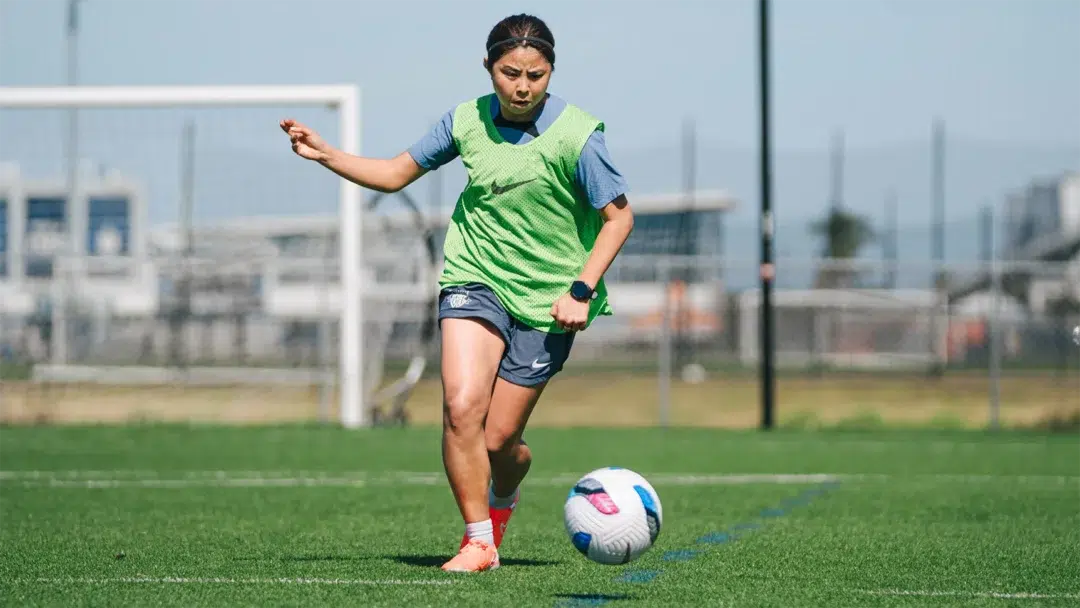 Narumi dribbles the ball.