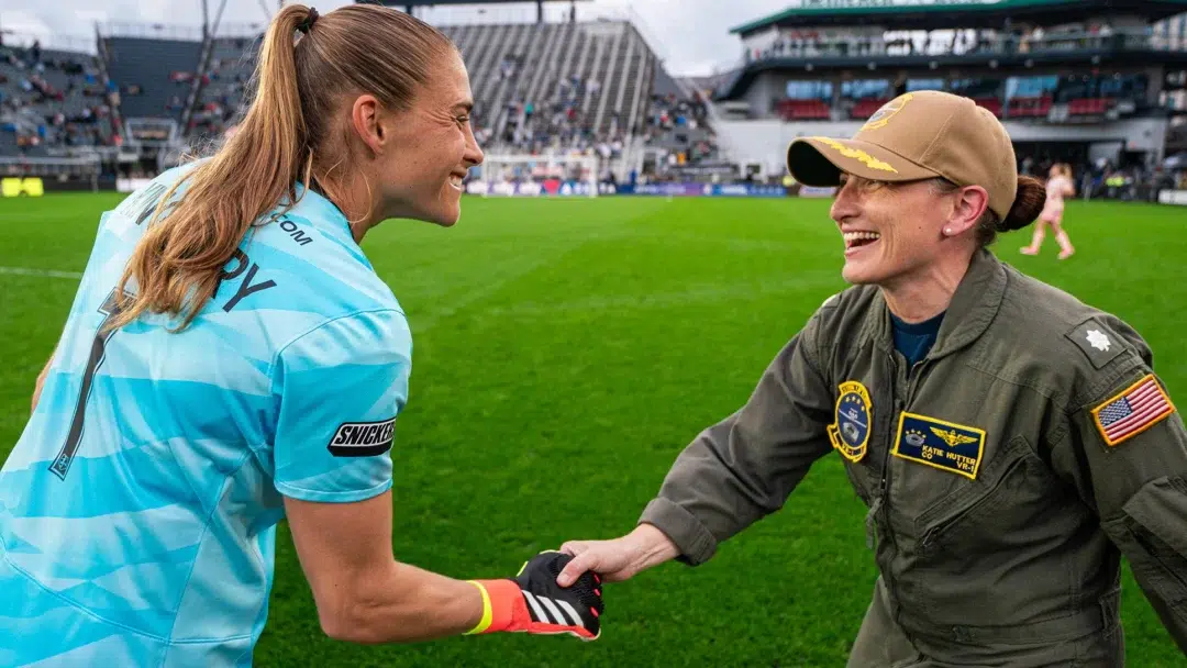 Aubrey Kingsbury shakes the hand of a military pilot.