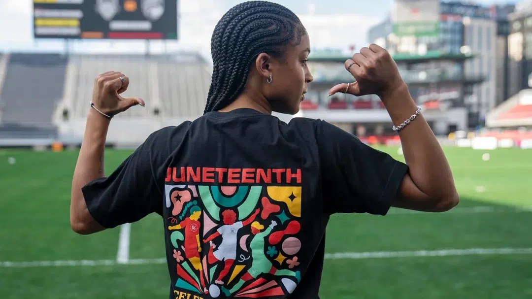 Croix Bethune shows off the back of her t-shirt which reads "Juneteenth, celebrate freedom"